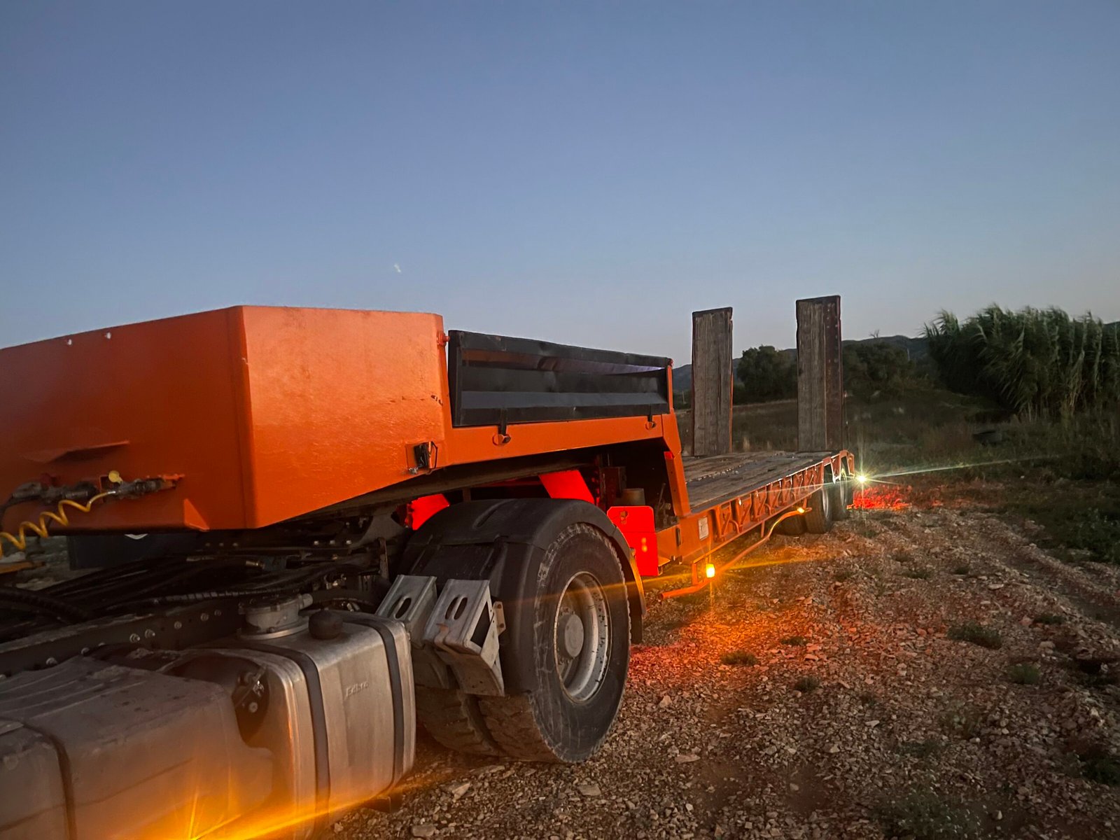 Remorque porte-char orange côté droit avec rampes pour transfert d engins TP et machines lourdes Sud Luberon NBLTP